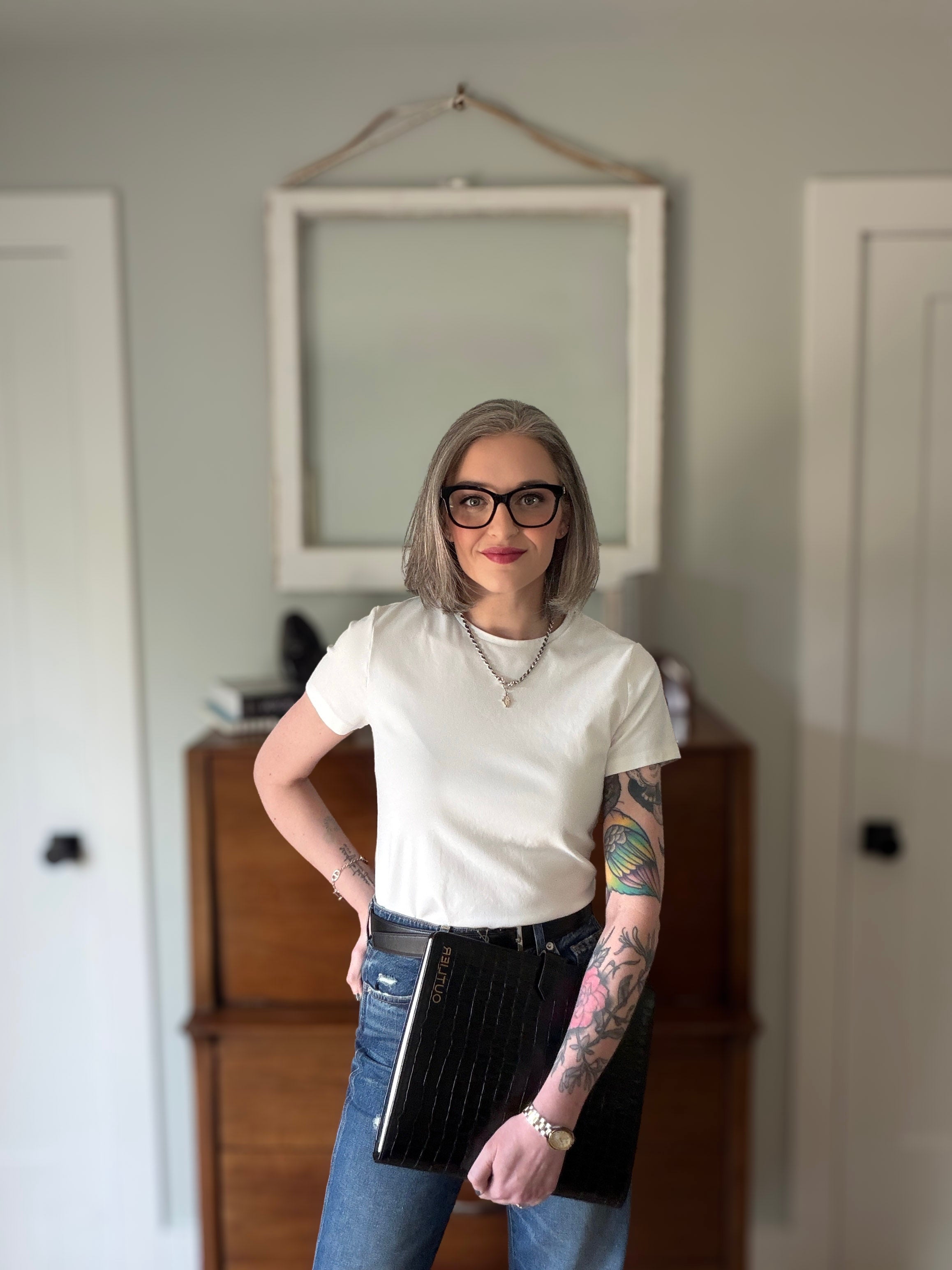Jessica J. Evans, Principal & Founder of CONTRA CLASS, holding a leather portfolio organizer from the Leather Goods collection.